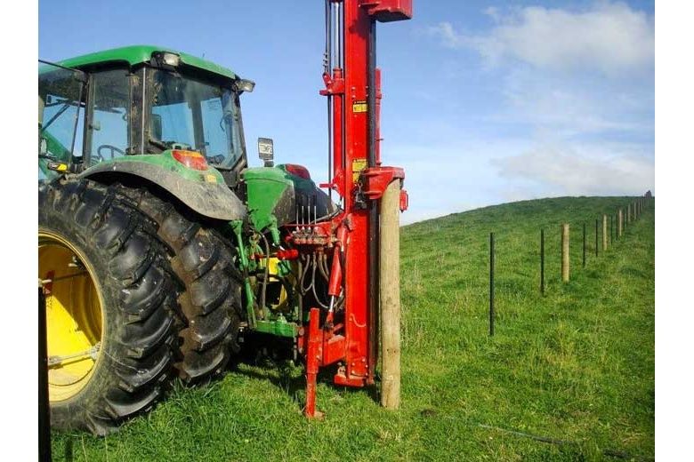 second hand Kinghitter Expander hammer raised up above fence post, John Deere tractor dual wheels